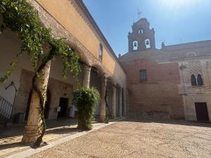 a courtyard of a building with a clock tower at Apartamentos Turísticos Las Claras 2 in Tordesillas