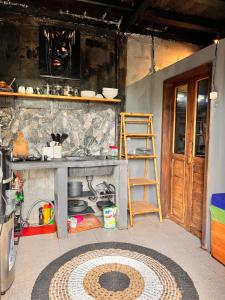 a kitchen with a counter with a sink and a ladder at My Kubu in Jembrana +5 photos