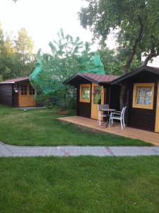 uma pequena cabana com uma mesa e cadeiras num quintal em House in the Garden em Pärnu