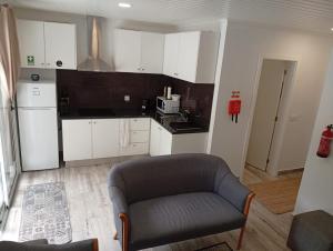 a living room with a couch and a kitchen at Danny's Rural Suite T2 in Curral das Freiras