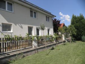 ein Haus mit einem Zaun und Pflanzen im Hof in der Unterkunft Dom v Záhrade in Podhájska