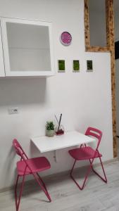 - une table blanche et 2 chaises roses dans la chambre dans l'établissement Monolocale Studio Flat, à Pérouse