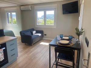 a living room with a table and a couch at Chouciña Apartments in Sanxenxo