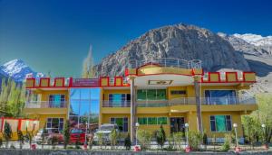 a yellow building with a mountain in the background at Skardu View Point Hotel and Huts in Skardu