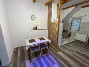 Habitación con mesa y cocina con reloj en Casa Olivia, en Buşteni