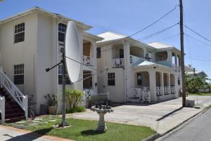 a large white house with a satellite at Clearwater Apartments in Christ Church