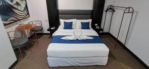 a bedroom with a bed with two white towels on it at Dancenter Boss Hotel Near Clark International Airport in Angeles