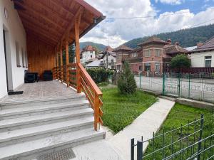 una casa con una escalera de madera que conduce a un patio en Casa Olivia, en Buşteni 4 fotos más
