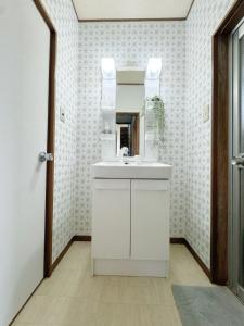 a bathroom with a white sink and a mirror at 5 mins walk from Yuzaki bus stop, sea view, parking lot, in Shirahama +22 photos