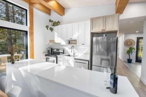 Spa and Sauna - Riverside - Brand New- SKOV Chalets في Saint Come: مطبخ مع خزائن بيضاء وثلاجة