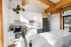 Spa and Sauna - Riverside - Brand New- SKOV Chalets في Saint Come: مطبخ بدولاب بيضاء وقمة بيضاء +49 صورة