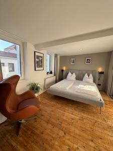 a bedroom with a bed and a chair in it at Designblick in Buttelstedt
