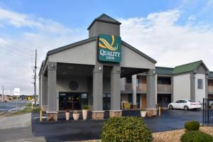 卡尔霍恩Quality Inn Calhoun North I-75的一栋挂着乡村旅馆标志的建筑