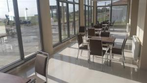 a row of tables and chairs in a room with windows at Gunes Hotel in Hacıbektaş