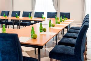 une rangée de tables et de chaises avec des bouteilles vertes dans l'établissement Hotel Olsza, à Olszówka