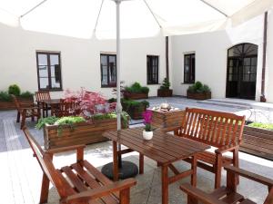 eine Terrasse mit Holzbänken und einem Sonnenschirm in der Unterkunft Dom na Podwalu in Lublin