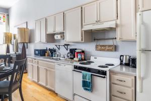 a kitchen with white cabinets and a white stove top oven at Free Parking Loft Suite Walk to Conv Center in San Diego +29 photos