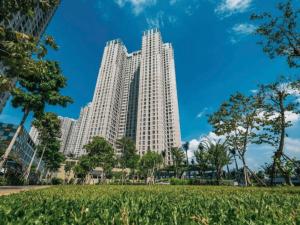 un edificio blanco alto con un parque delante de él en Masteri Thao Dien Apartment Complex, en Kon Rung (1)