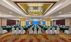 a large banquet hall with green tables and white chairs at Golden Sea View Hotel Haikou in Haikou