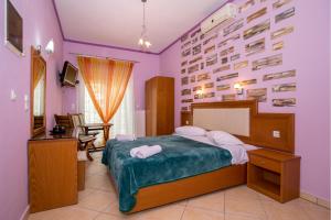 a bedroom with a bed and a desk and a television at Balkan House in Potos