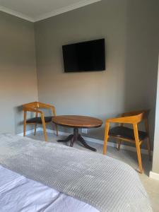 1 dormitorio con mesa, 2 sillas y TV en The Perfect Spot, en Welgelegen 14 fotos más