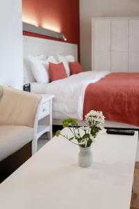 a bedroom with two beds and a table with a vase of flowers at Rudolfo Hotel in Lviv
