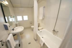 a bathroom with a sink, toilet and bathtub at Hotel Pyrénées in Andorra la Vella