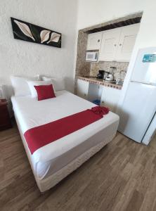 a bedroom with a large white bed and a kitchen at “Magic Sunrise at Cancun” in Cancún
