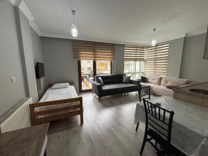 a living room with a couch and a bed and a table at SİMGE Apt in Trabzon