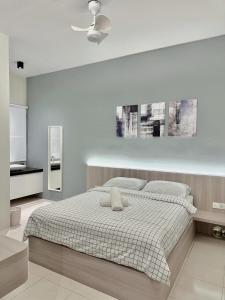 ein weißes Schlafzimmer mit einem Bett und einer Decke in der Unterkunft Tanah Rata Cameron Jaya cottage has plenty of hot water, a spacious living room in Tanah Rata