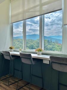 ein Raum mit Tisch und Stühlen und einem großen Fenster in der Unterkunft Tanah Rata Cameron Jaya cottage has plenty of hot water, a spacious living room in Tanah Rata