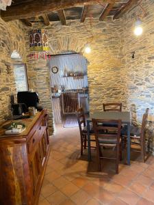 a dining room with a table and chairs and a stone wall at La Casa Del Cacao in Lecchiore +26 photos