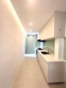 a kitchen with white cabinets and a sink at Urban Hub Near the Bund nice view big apartment 2bathrooms in Shanghai