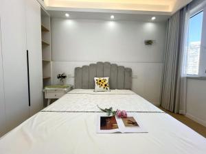 a bedroom with a bed with a book and flowers on it at Urban Hub Near the Bund nice view big apartment 2bathrooms in Shanghai