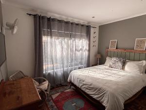 a bedroom with a bed and a window at Modern Retreat at Hout Bay Beach in Hout Bay