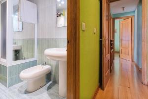 a bathroom with a white toilet and a sink at Vivienda turística Felicia in León