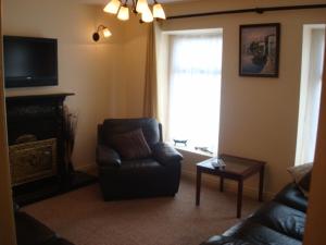 sala de estar con sofá, silla y ventana en Swinford Bridge Street Apartment en Swinford