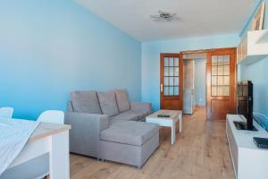 a living room with a couch and a table at Vivienda Turística Osiris in San Andrés del Rabanedo