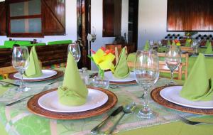 a table with green napkins on plates with wine glasses at The Wooden House Hotel in Puerto Villamil