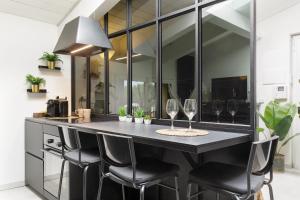a kitchen with a bar with two wine glasses at Tranquility Inn- 25 min Duomo M1 in Sesto San Giovanni