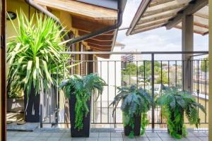 a balcony with two potted plants on a building at Tranquility Inn- 25 min Duomo M1 in Sesto San Giovanni