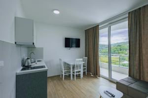 a kitchen and living room with a view of a balcony at Green panorama Vrdnik in Vrdnik