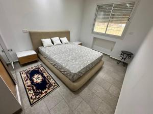Un dormitorio pequeño con una cama y una ventana. en Villa Azur, en Ḩammām al Ghazzāz
