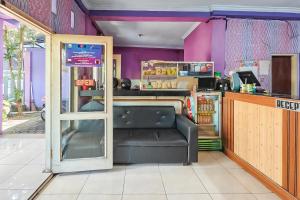 a restaurant with a black leather bench in a room at RedDoorz near Kopeng Salatiga 