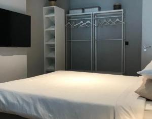 a bedroom with a white bed and a tv at Hotel chic room in Heerlen
