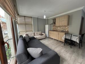 a living room with a couch and a kitchen at SİMGE Apt in Trabzon