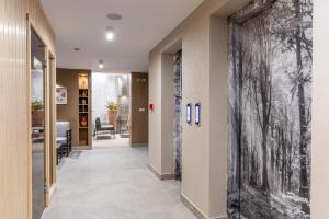 a hallway with a large black and white painting on the wall at Spa Hotel Persenk in Devin
