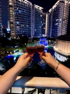 two people holding glasses of wine on a balcony at Dream Escapade in Manila