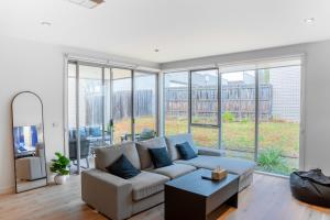 a living room with a couch and large windows at Shared House in Melbourne in Bundoora