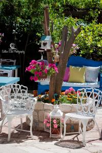 a group of white chairs and a table with flowers at Morlimon in Alaçatı